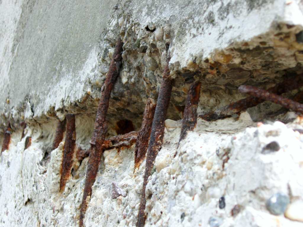 Exposed and corroded rebar within severely damaged concrete structure